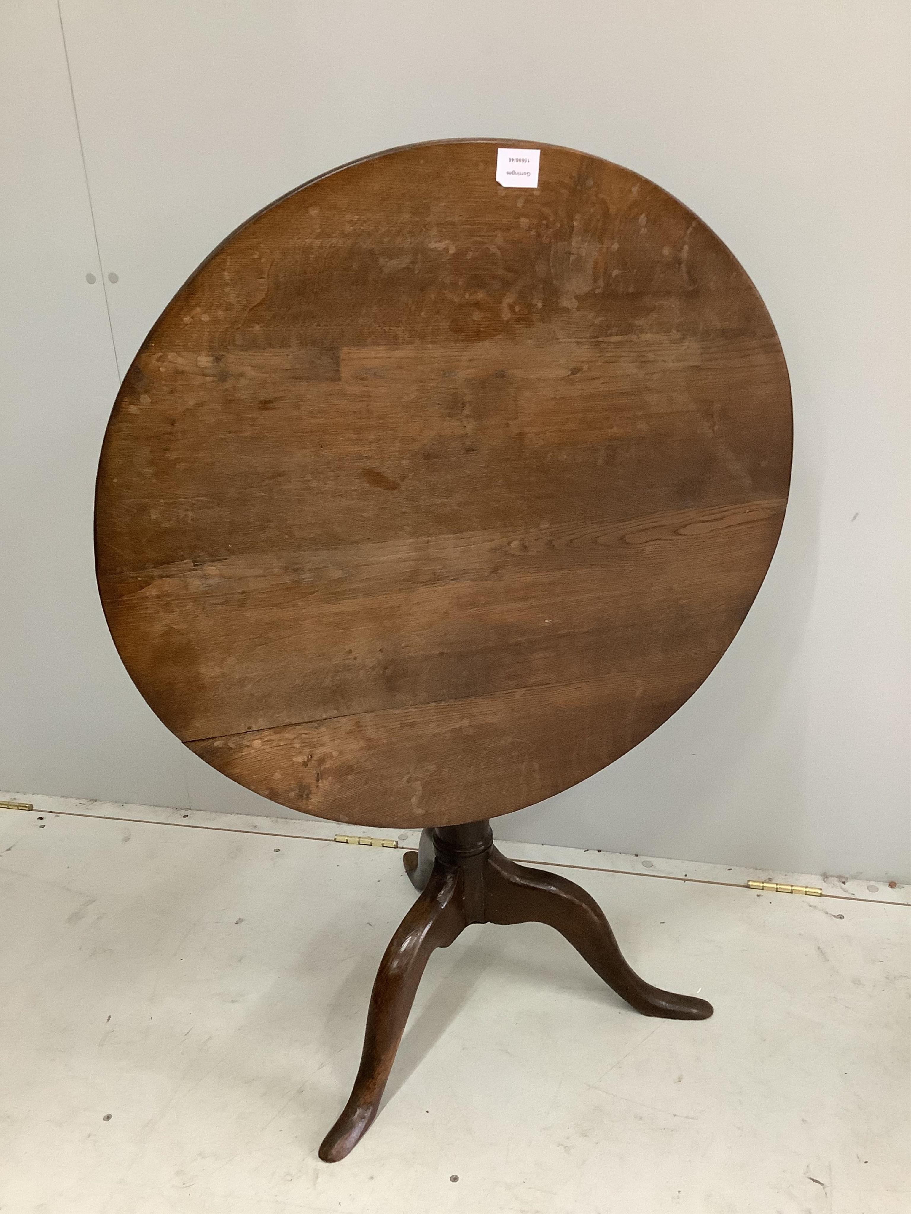 A George III circular oak tilt top tripod table, diameter 76cm. Condition - restorations